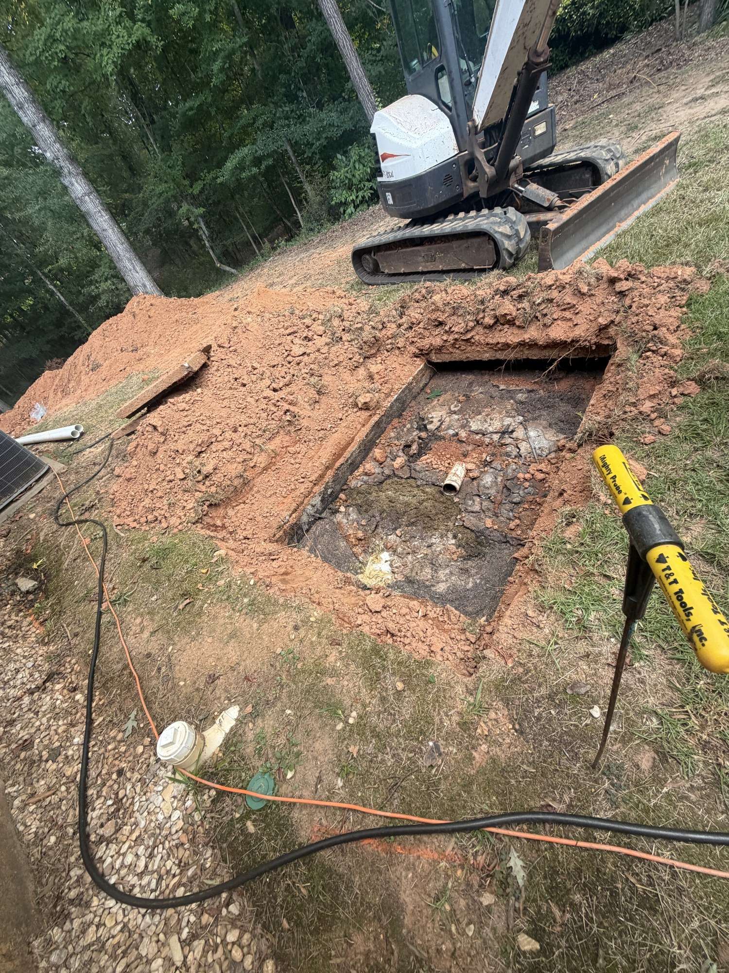 Septic tank dug up with an excavator for repair