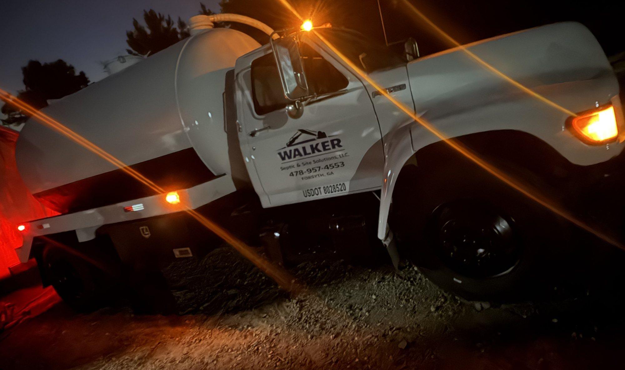 Walker Septic pump truck at night, amber marker lights on