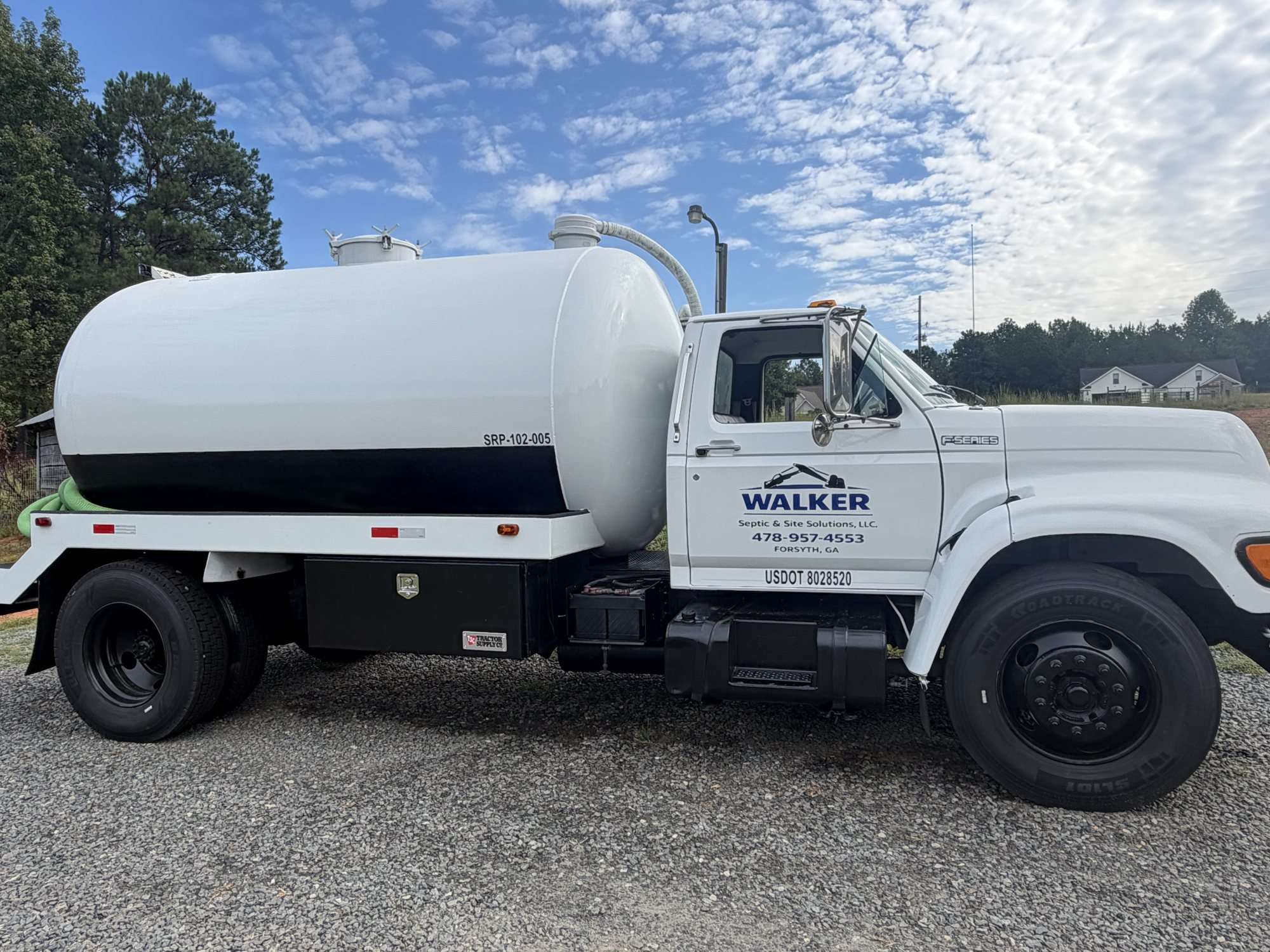 Walker Septic pump truck from the side, logo and phone number on the door